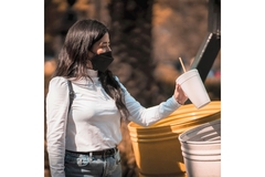 Image A girl throwing away a single-use cup in the trash.